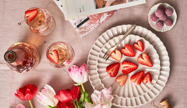 Schlumberger Sparkling Spring Gläser mit Erdbeeren in Herzchenform auf gedecktem Tisch 