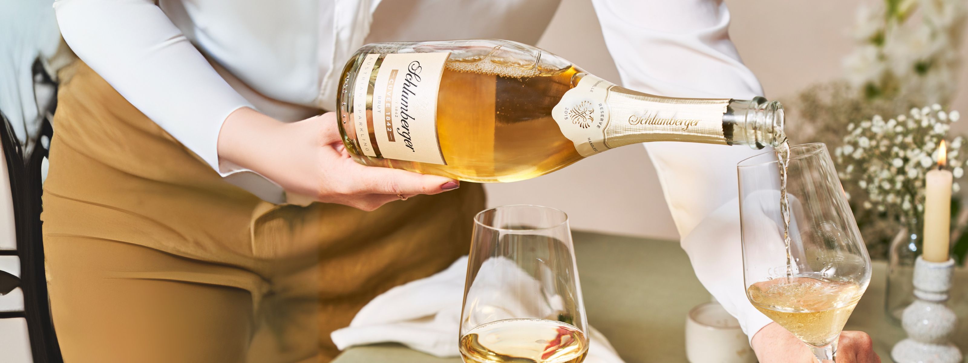 Dame schenkt eine Flasche Cuvee 1842 ein