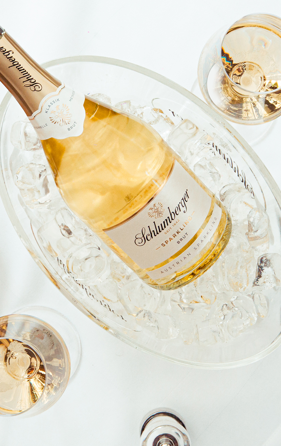 Schlumberger Sparkling Brut im Sektkühler auf gedecktem Tisch.
