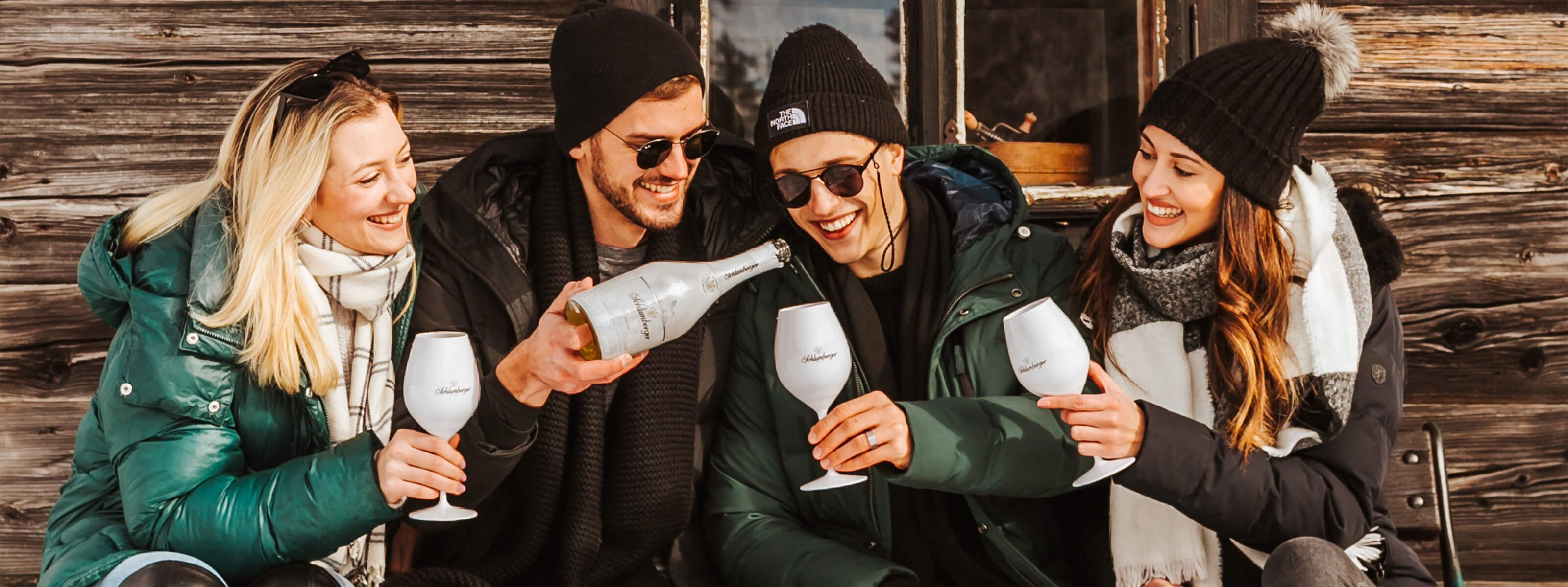 Freude stoßen mit Schlumberger White Ice Secco vor einer Hütte an