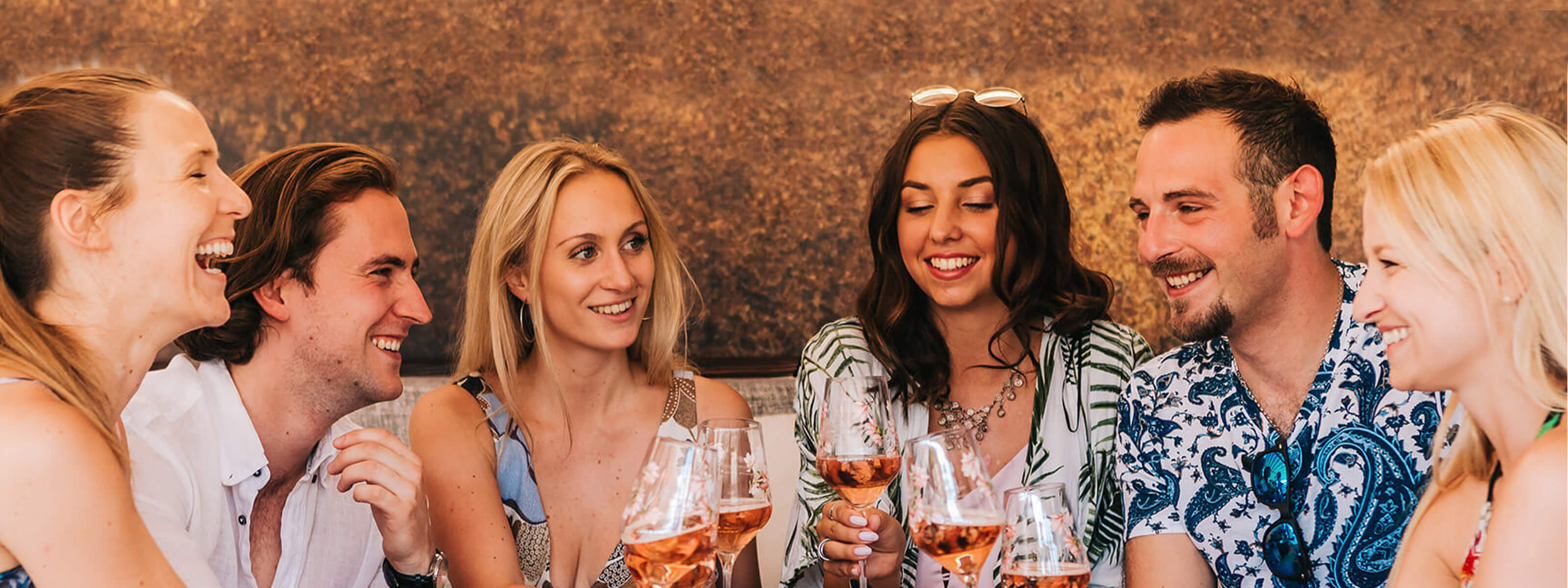 Freunde sitzen in Gastronomie und genießen ein Glas Schlumberger Rosé