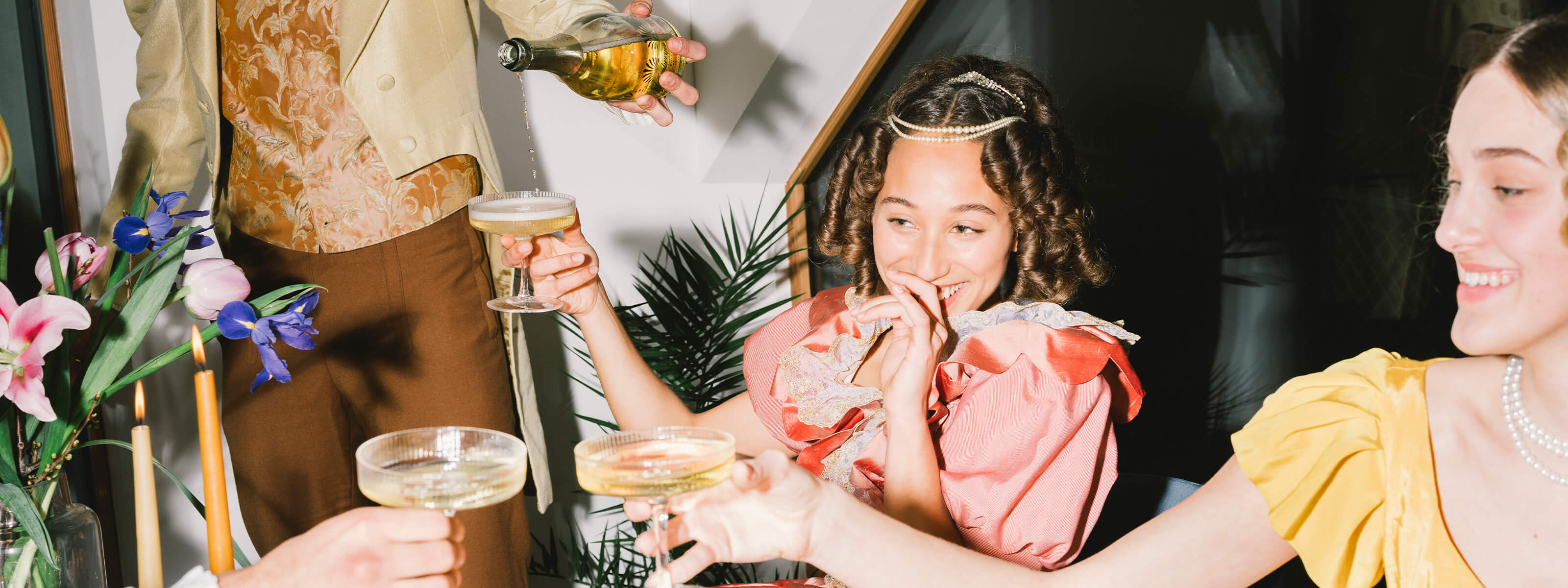 Damen sitzen bei Tisch und trinken Sekt