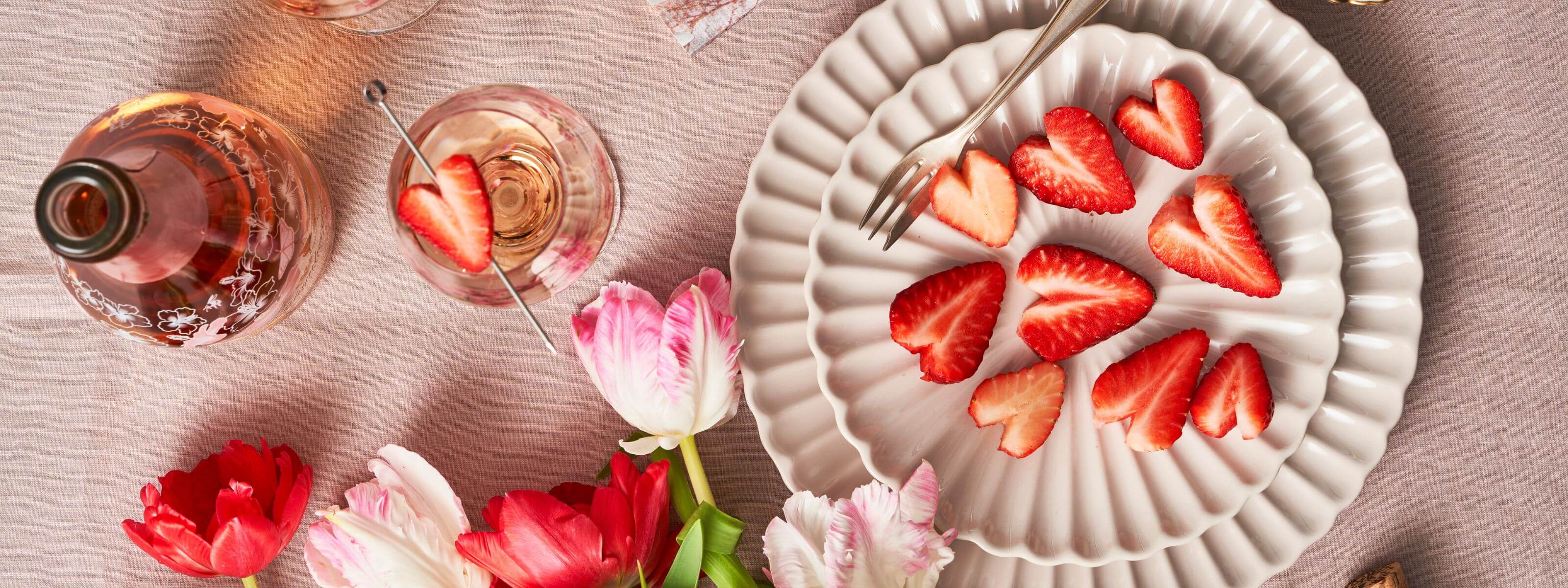 Tisch mit Schlumbgerger Spring Edition und Erdbeeren, welche in Herzform geschnitten wurden