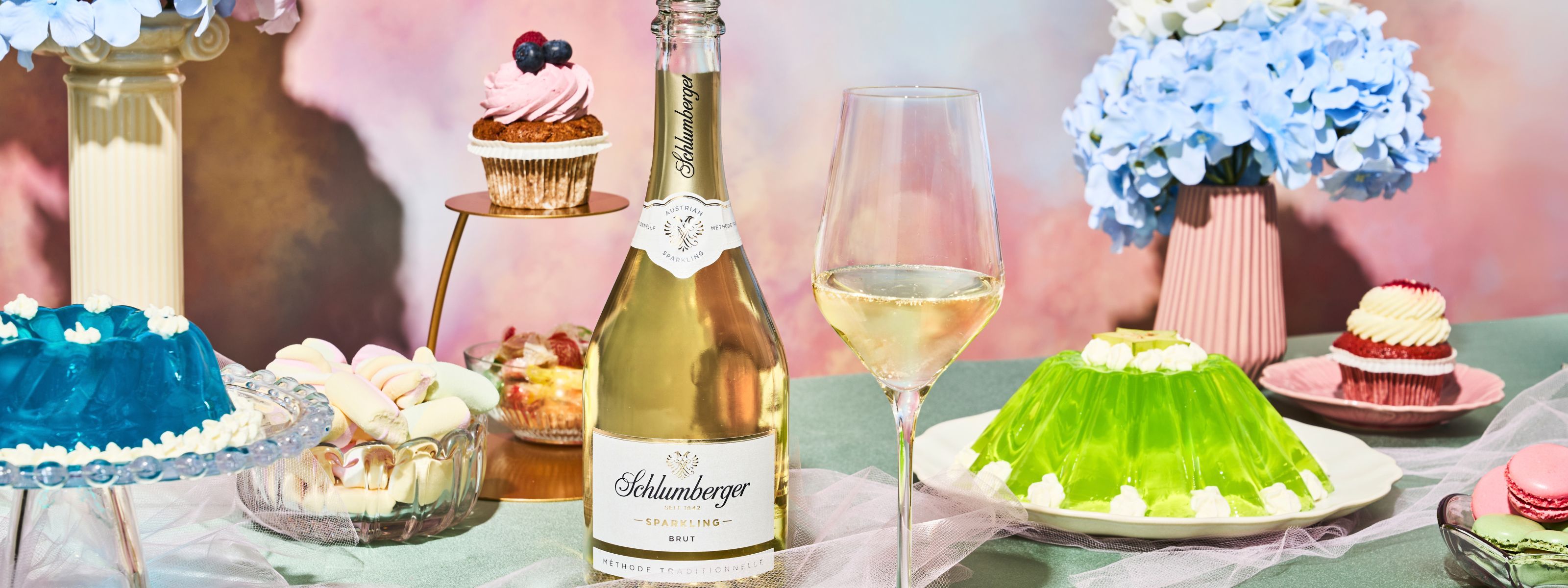 Flasche Sparkling Brut steht auf einem TIsch mit grünem und blauen Wackelpudding