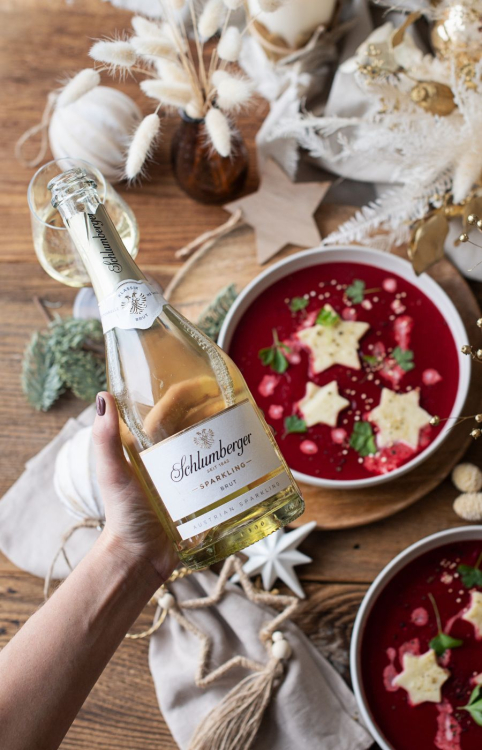 Roterübernsuppe mit Brutsternen steht am Tisch und es wird ein Glas mit Schlumberger Sparkling eingeschenkt