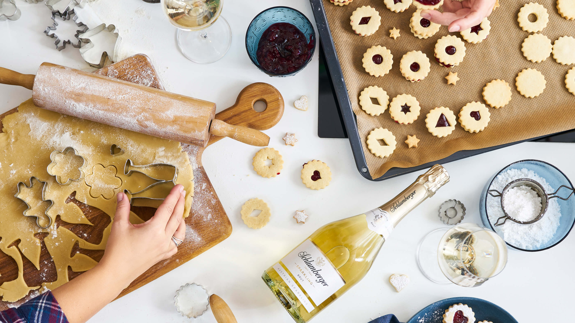 Gruppe beim gemeinsamen Kekse backen mit einer Flasche Schlumberger Sparkling Brut Klassik