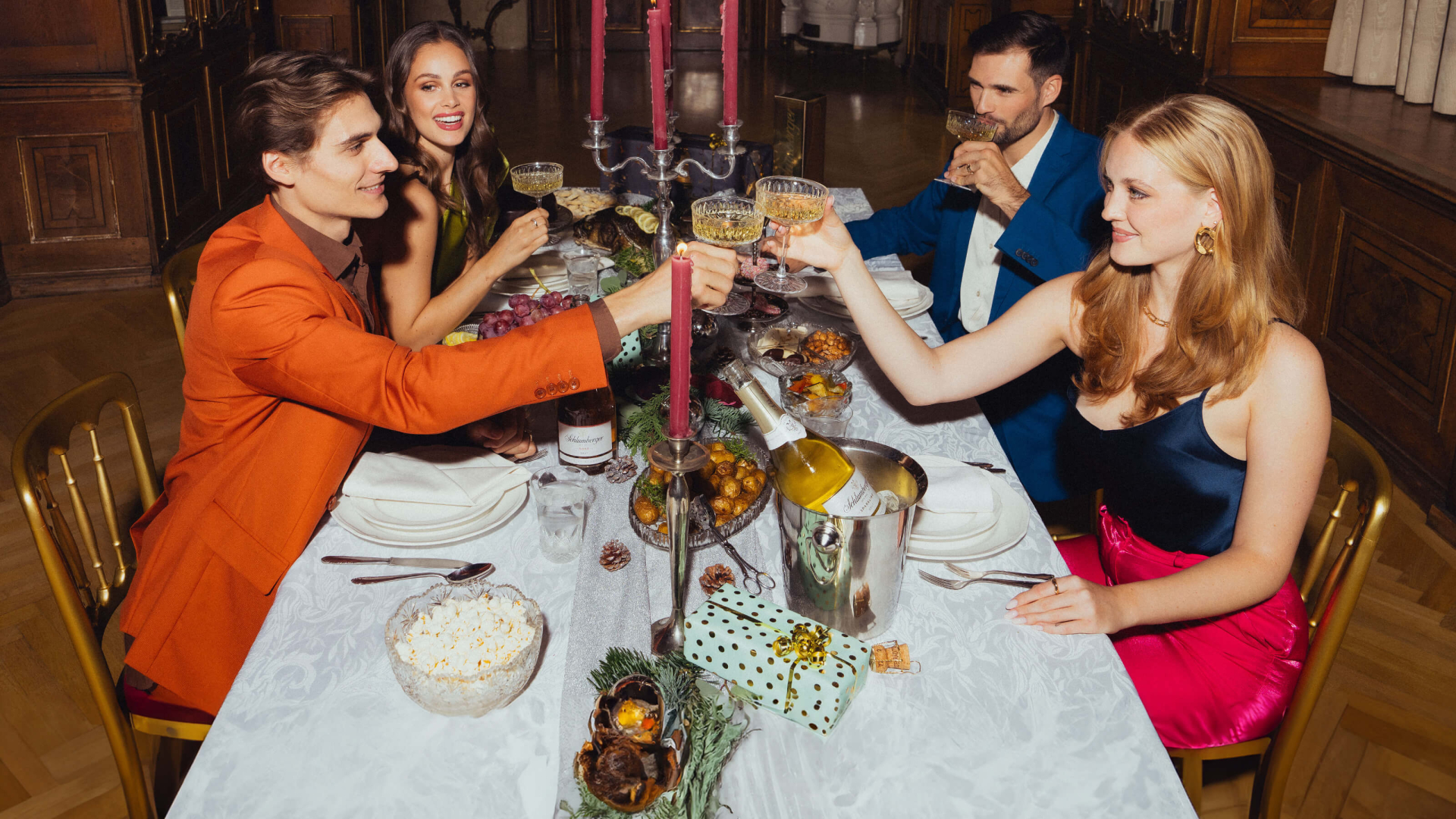 Personen gemütlich beisammen auf gedecktem Tisch mit einem Glas Schlumberger Sparkling Brut
