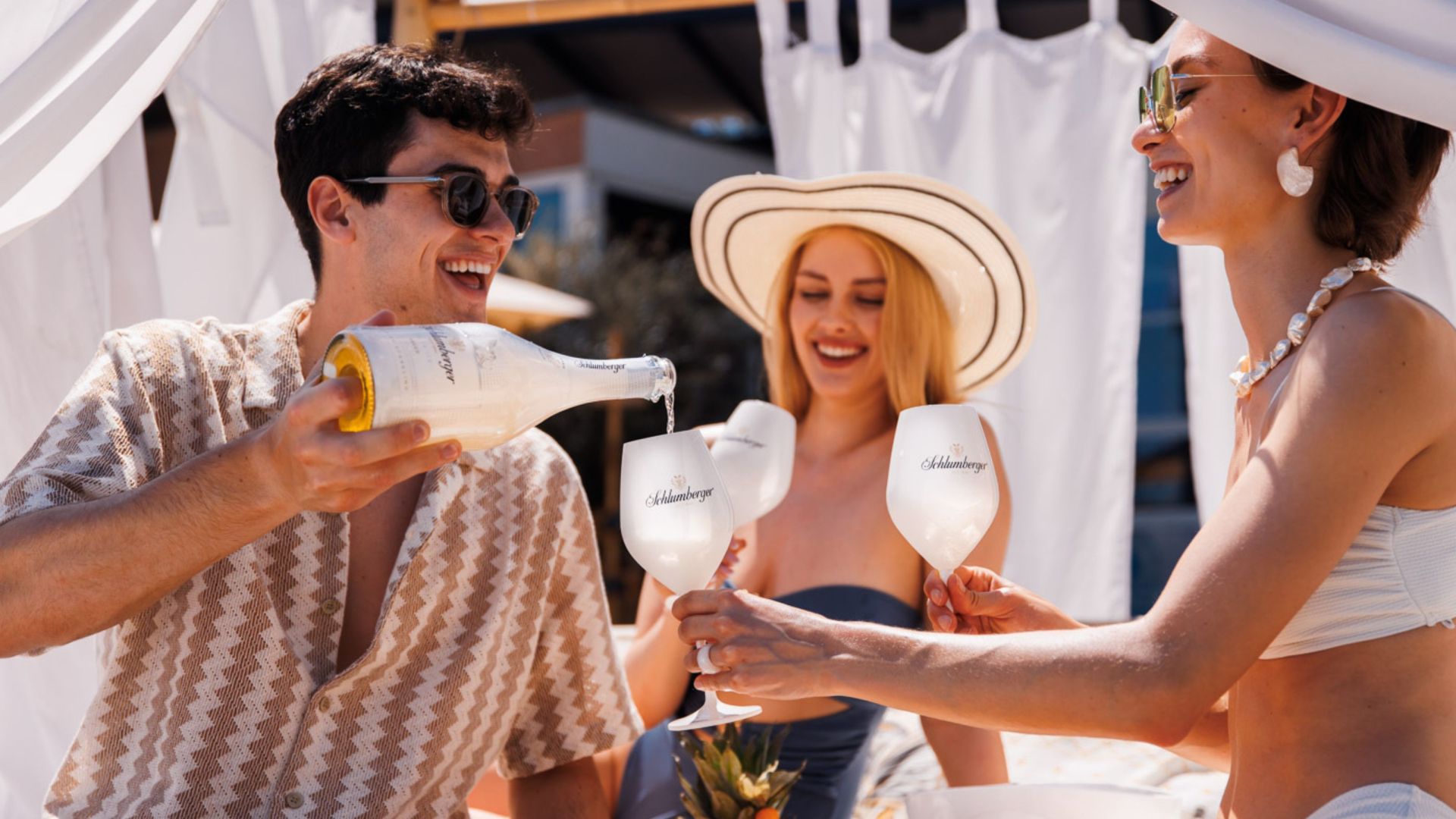 Freunde sietzten in der Sonne und trinken Schlumberger Ice Secco