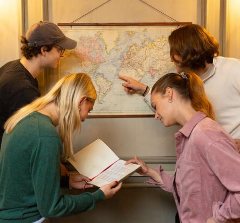 Vier Personen schauen auf eine Landkarte