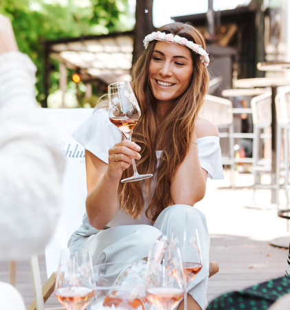 Dame trinkt im Freien ein Glas Rosé Sekt