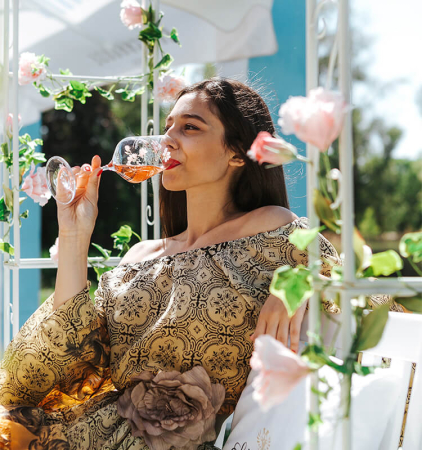 Dame trinkt im Freien ein Glas Rosé Sekt
