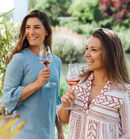 Damen trinken im Freien ein Glas Rosé Sekt