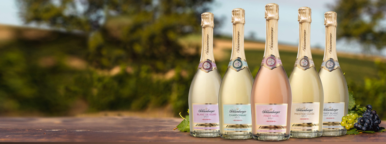 Schlumberger Reserve Linie bestehend aus den fünf Sorten, Chardonnay Brut Reserve, Prestige Cuvée Brut Reserve, Pinot Noir Brut Reserve, Blanc de Noirs Brut Reserve und Pinot Blanc Brut Nature Reserve mit Weingut Hintergrund