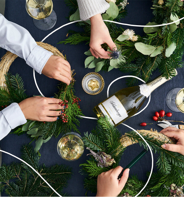 Freunde binden gemeinsam einen Adventkranz mit Schlumberger Sparkling