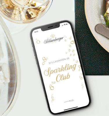 Schlumberger Sparkling Club App liegt geöffnet am Tisch