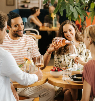 Mann schenkt an einem Tisch Rosé Spring ein
