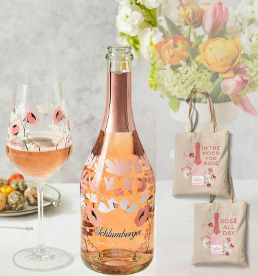 Flasche und Glas stehen am Tisch, daneben sind Stofftaschen abgebildet