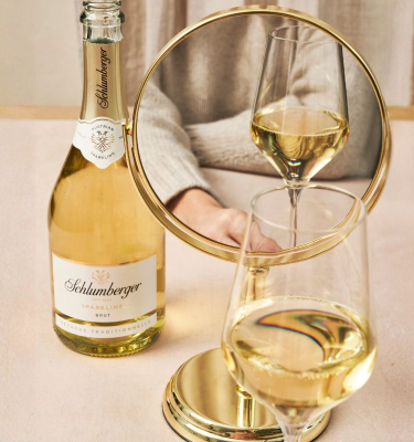 Dame sitzt vor Spiegel mit einer Flasche Sparkling und einem Glas