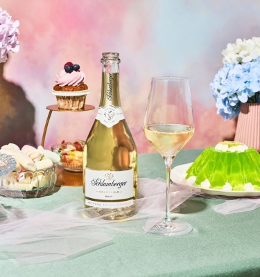 Flasche Sparkling Brut steht auf einem TIsch mit grünem und blauen Wackelpudding