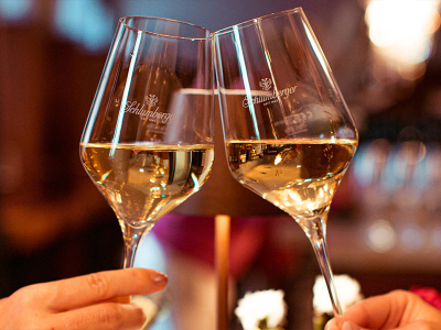 Zwei Gläser Schlumberger Schaumwein beim Anstoßen.