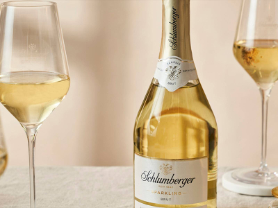 Eine Flasche Schlumberger Sekt und zwei volle Gläser auf einem Tisch.