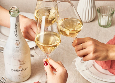 Drei Personen stoßen mit einem Glas Ice Secco an