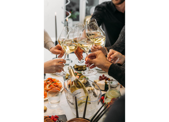 Freunde stoßen mit einem Glas Sekt an