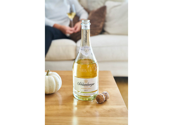 Sparkling Flasche steht geöffnet am Tisch mit Kork daneben