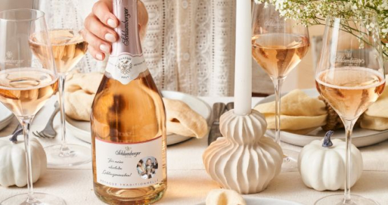Schlumberger Rosé Flasche mit personalisiertem Etikett wir von Dame auf den Tisch gestellt.