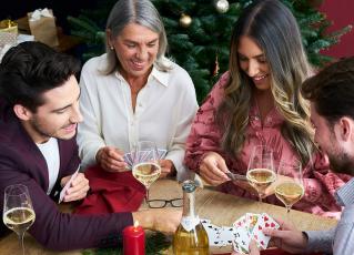 Familie spielt Karten und trinkt Schlumberger Sparkling
