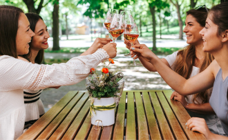 Vier Damen stoßen im Gastro mit Rosé Sekt an