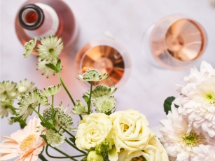 Blumen und Rosé Brut sowie Gläser stehen am Tisch
